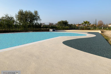 Esempio di una piscina naturale stile marino personalizzata in cortile con pavimentazioni in pietra naturale