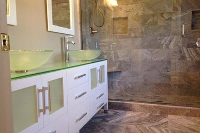 Inspiration for a mid-sized modern master beige tile and porcelain tile porcelain tile and beige floor alcove shower remodel in Other with glass-front cabinets, white cabinets, beige walls, a vessel sink, glass countertops and a hinged shower door