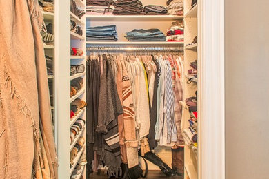 Example of a small classic gender-neutral medium tone wood floor walk-in closet design in Orange County with open cabinets and white cabinets