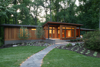 Inspiration for a mid-sized modern one-storey beige exterior in DC Metro with wood siding and a shed roof.