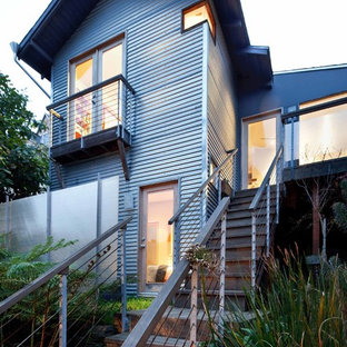 Foto på ett litet industriellt grått lägenhet, med två våningar, metallfasad och sadeltak