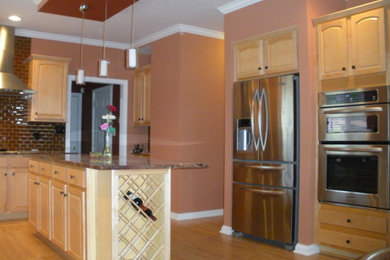Large u-shaped light wood floor eat-in kitchen photo in Indianapolis with beaded inset cabinets, light wood cabinets, granite countertops, brown backsplash, stainless steel appliances and an island