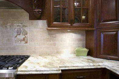 Kitchen - mediterranean l-shaped kitchen idea in Cincinnati with raised-panel cabinets, dark wood cabinets, marble countertops, beige backsplash, mosaic tile backsplash and stainless steel appliances