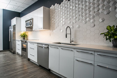 Mid-sized modern single-wall eat-in kitchen in Toronto with an undermount sink, flat-panel cabinets, white cabinets, quartz benchtops, white splashback, ceramic splashback, stainless steel appliances, with island and white benchtop.