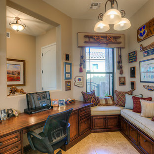 This is an example of a small modern study in Phoenix with beige walls, travertine flooring and a built-in desk.