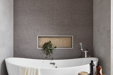 Example of a trendy gray tile mosaic tile floor and gray floor freestanding bathtub design in Other