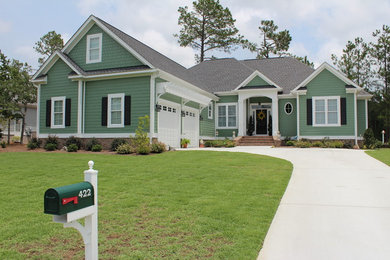Large elegant green two-story wood exterior home photo in Other with a shingle roof