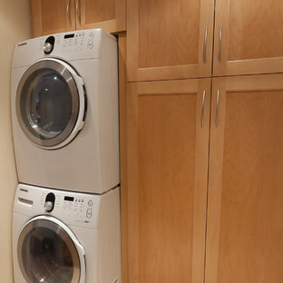 Medium sized traditional single-wall separated utility room in San Diego with shaker cabinets, light wood cabinets and a stacked washer and dryer.