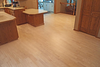 Kitchen - mid-sized modern light wood floor kitchen idea in Other with raised-panel cabinets, medium tone wood cabinets, laminate countertops and an island