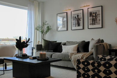 Foto de salón abierto minimalista de tamaño medio sin chimenea con paredes beige, suelo de madera clara y televisor colgado en la pared