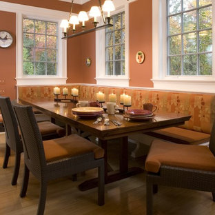 Idée de décoration pour une salle à manger design avec un mur orange.