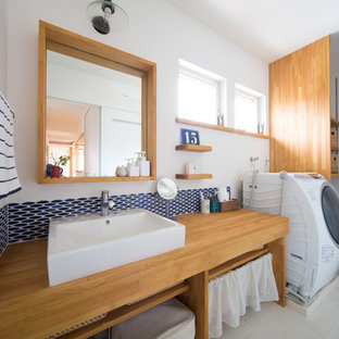 This is an example of a scandinavian single-wall utility room in Other with open cabinets, wood worktops, white walls, an integrated washer and dryer and medium wood cabinets.