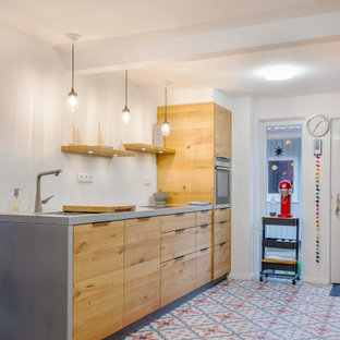 Foto på ett mellanstort minimalistiskt kök, med en undermonterad diskho, släta luckor, skåp i mellenmörkt trä, bänkskiva i betong, vitt stänkskydd, glaspanel som stänkskydd, rostfria vitvaror och klinkergolv i porslin