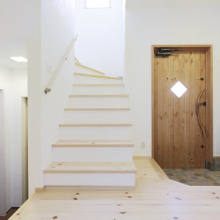 他の地域の片開きドアカントリー風おしゃれな玄関 (白い壁、木目調のドア) の写真