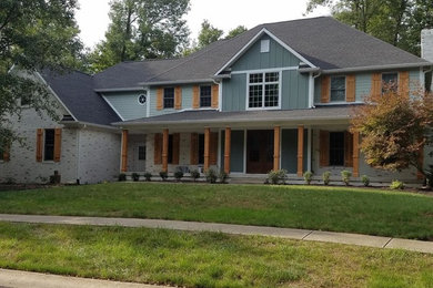 Example of a large country green two-story mixed siding exterior home design in Indianapolis with a shingle roof