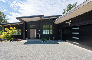 Modelo de fachada de casa negra y gris moderna de tamaño medio de dos plantas con revestimiento de madera, tejado de un solo tendido, tejado de metal y tablilla