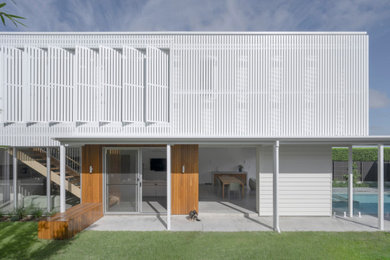 Photo of a mid-sized contemporary front door in Sunshine Coast with white walls, concrete floors, a sliding front door, a glass front door, grey floor and wood walls.