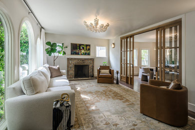 Transitional medium tone wood floor and brown floor living room photo in San Francisco with white walls, a standard fireplace and a tile fireplace