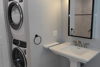 Minimalist laundry room photo in Boston with a single-bowl sink and a stacked washer/dryer