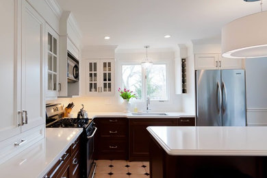 Elegant l-shaped ceramic tile enclosed kitchen photo in Toronto with a single-bowl sink, shaker cabinets, white cabinets, quartz countertops, white backsplash, ceramic backsplash, stainless steel appliances and an island