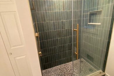 Modelo de cuarto de baño principal minimalista de tamaño medio con baldosas y/o azulejos verdes, suelo con mosaicos de baldosas, suelo gris y ducha con puerta corredera