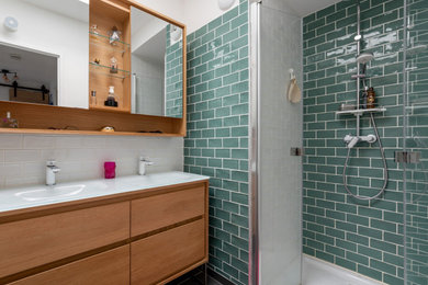 Modelo de cuarto de baño doble moderno con ducha a ras de suelo, baldosas y/o azulejos verdes, suelo de baldosas de terracota, lavabo tipo consola, encimera de vidrio, suelo gris, ducha con puerta con bisagras y encimeras blancas