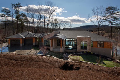 Example of a large minimalist multicolored one-story mixed siding house exterior design in Other with a hip roof and a mixed material roof
