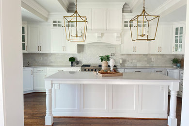Example of a huge transitional u-shaped medium tone wood floor, brown floor and tray ceiling eat-in kitchen design in Baltimore with a farmhouse sink, shaker cabinets, white cabinets, quartz countertops, white backsplash, subway tile backsplash, stainless steel appliances, an island and white countertops