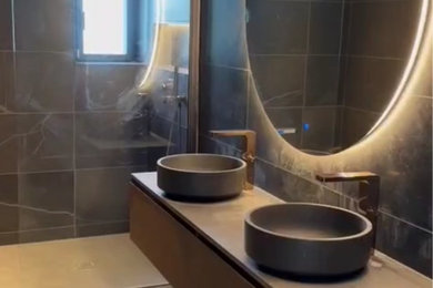 Cette photo montre une salle de bain moderne avec une douche à l'italienne, WC à poser, un carrelage noir, du carrelage en marbre, un sol en marbre, un plan vasque, un plan de toilette en marbre, un plan de toilette noir et meuble double vasque.
