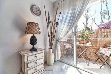 Modelo de salón abierto romántico pequeño con paredes blancas, suelo de mármol, televisor colgado en la pared y suelo gris