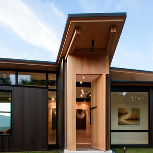 Foto de puerta principal minimalista con puerta pivotante, puerta de madera en tonos medios y paredes beige