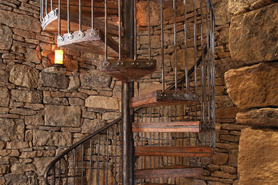 Example of a large mountain style wooden spiral open staircase design in Denver