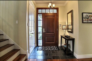 Example of a mid-sized trendy slate floor and black floor front door design in Montreal with beige walls and a medium wood front door