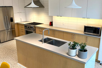 Example of a mid-sized trendy porcelain tile and gray floor eat-in kitchen design in Toronto with an undermount sink, flat-panel cabinets, quartz countertops, white backsplash, stainless steel appliances and an island