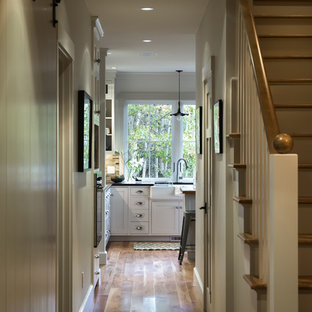 Idéer för att renovera en mellanstor vintage hall, med vita väggar och mellanmörkt trägolv