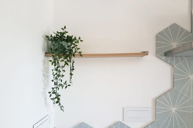 Cette image montre une cuisine ouverte linéaire et encastrable design de taille moyenne avec un évier de ferme, des portes de placard blanches, un plan de travail en bois, une crédence bleue, une crédence en carreau de ciment, un sol en carrelage de céramique, îlot, un sol beige et un plan de travail beige.