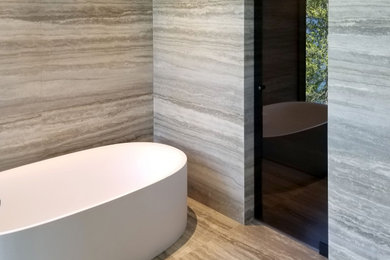 Cette image montre une très grande salle de bain principale design avec une douche ouverte, un carrelage gris, des dalles de pierre, un sol en calcaire, un plan de toilette en calcaire, un sol gris, un plan de toilette gris et meuble-lavabo suspendu.