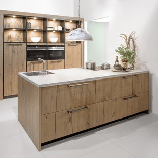 Design ideas for a mid-sized contemporary galley kitchen pantry in Christchurch with a drop-in sink, flat-panel cabinets, medium wood cabinets, laminate benchtops, stainless steel appliances and with island.