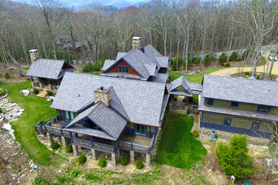 Example of a huge arts and crafts multicolored three-story mixed siding exterior home design in Charlotte with a shingle roof