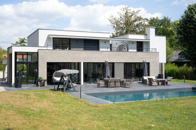 Aménagement d'une façade de maison contemporaine à un étage avec un toit plat.