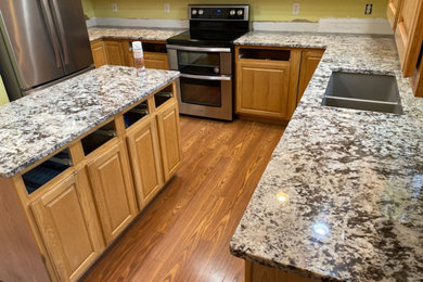 Eat-in kitchen - mid-sized traditional l-shaped eat-in kitchen idea with a double-bowl sink, an island, white countertops and granite countertops