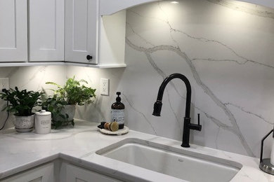 Example of a trendy kitchen design in Tampa with shaker cabinets, white cabinets and quartz countertops
