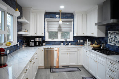 Inspiration for an eclectic porcelain tile and gray floor kitchen remodel in Providence with an undermount sink, white cabinets, quartzite countertops, blue backsplash, stainless steel appliances and white countertops