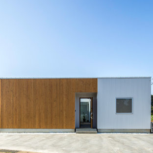 他の地域のアジアンスタイルのおしゃれな家の外観 (混合材サイディング、茶色い外壁、片流れ屋根、戸建、金属屋根) の写真