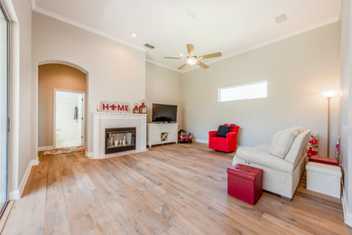 Family room - large country open concept light wood floor and beige floor family room idea in Orlando with gray walls, a standard fireplace, a tile fireplace and a tv stand