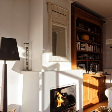 Cheminée classique en staff foyer ouvert habillé de plaques d'acier