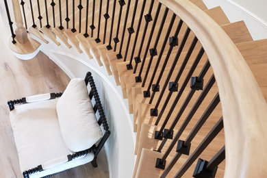 This is an example of a large traditional wood curved staircase in Los Angeles with wood railing.