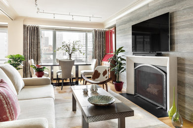 Contemporary open concept living room in New York with beige walls, medium hardwood floors, a standard fireplace, a wall-mounted tv and brown floor.