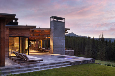 Inspiration for a rustic backyard stone patio remodel in Other with a fireplace