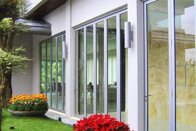 Mid-sized minimalist white two-story stucco exterior home photo in Hawaii with a metal roof